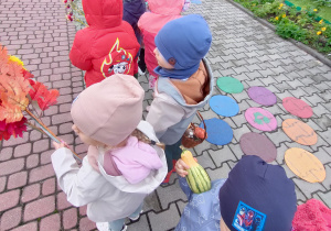 Widok na dzieci oraz Panie uczestniczące w jesiennym przemarszu ulicami miasta.