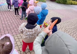 Widok na dzieci oraz Panie uczestniczące w jesiennym przemarszu ulicami miasta.