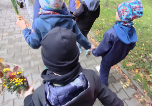 Widok na dzieci oraz Panie uczestniczące w jesiennym przemarszu ulicami miasta.