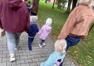 Widok na dzieci oraz Panie uczestniczące w jesiennym przemarszu ulicami miasta.