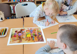 Widok na dzieci kolorujące kolorowankę.