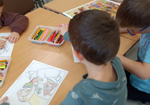 Widok na dzieci kolorujące kolorowankę.