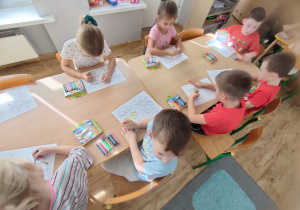 Widok na dzieci kolorujące nową postać - postać Uszko.