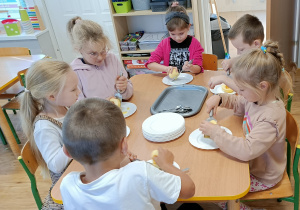 Widok na dzieci podczas tarcia jabłek na tarce.