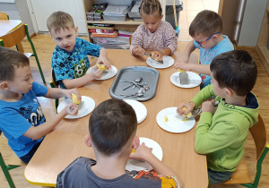 Widok na dzieci podczas tarcia jabłek na tarce.