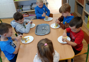 Widok na dzieci podczas tarcia jabłek na tarce.