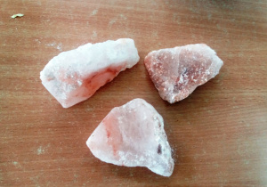 Trzy dość duże, różowo zabarwione odpryski skalne soli przywiezione z kopalni soli w Wieliczce.
