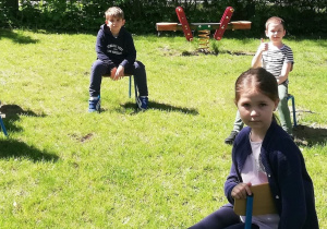 Sześcioro dzieci siedzi na krzesełeczkach w ogrodzie przedszkolnym.