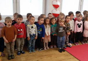 Maluszki i Maluchy stoją biorąc udział w akcji wspólnego śpiewania hymnu narodowego.