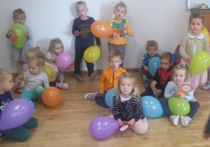 Widok na dzieci trzymające w rękach kolorowe balony.