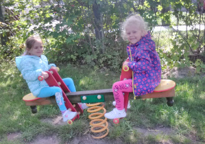 2 dziewczynki huśtają się na „bujawce”.