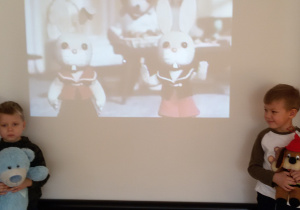 Widok na dwóch chłopców stojących przed ekranem projekcyjnym.