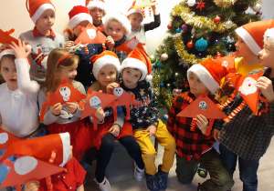 Dzieci prezentują wykonane Mikołaje z papieru