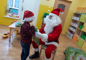 Mikołaj wręcza chłopcu prezent