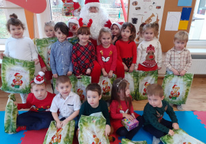 Grupka dzieci pozuje do zdjęcie z Mikołajem