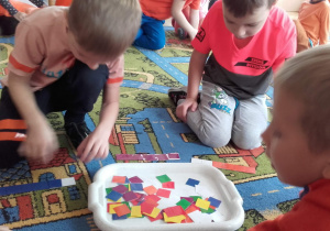 Dzieci dopasowują kwadratowe puzzle według wzoru