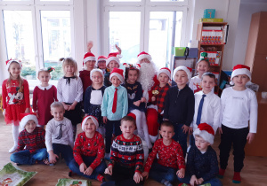 Cała grupa dzieci pozuje do zjęcia z Mikołajem