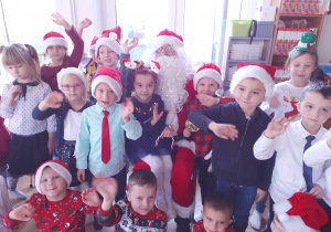 Cała grupa dzieci pozuje do zjęcia z Mikołajem